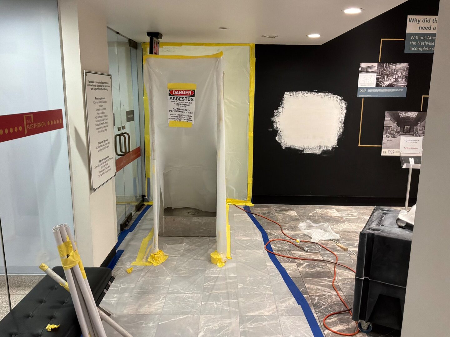 Asbestos containment vestibule staged in a museum lobby
