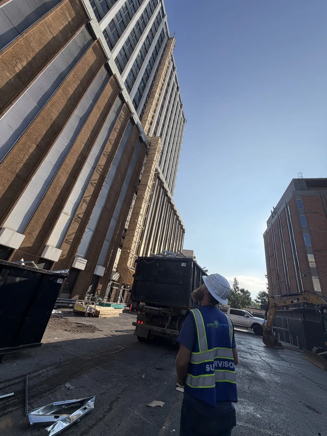 Site supervisor monitoring a debris chute on a high-rise